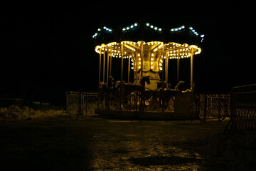 children's carousel in a closed park at night