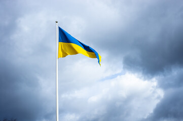 Sea pennant in Swedish flag colors on cloudy dramatic sky background. 6 June. Flag of Sweden waving high on the flagpole. Celebration Holiday National Day Festive Event. 