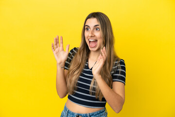 Young caucasian woman isolated on yellow background with surprise facial expression