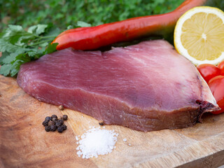 Fresh and raw tuna steak with chili peppers and olive oil