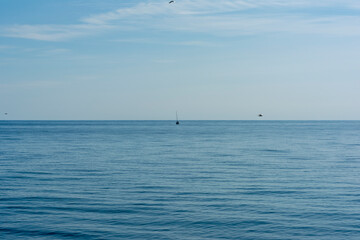the blue surface of the sea against the background of a cloudless sky in sunny weather