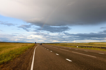 Road among fields. Rainbow after rain. Russian landscape