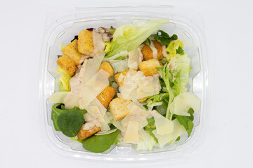 Simple Takeout Caesar Salad in a Plastic Container with a White Background