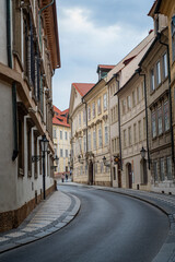 Fototapeta na wymiar street of the old town in Prague, Czech Republic, Europe. Ancient houses with light, beautiful facades. Road on the street between houses.