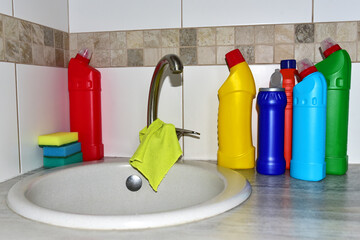 Detergent bottles near the kitchen sink in home. Detergents and laundry concept. Household...