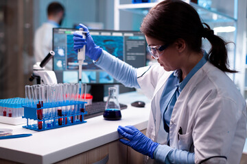 Scientist looking into micropipette for biology test, science disease, healthcare. Woman research a...