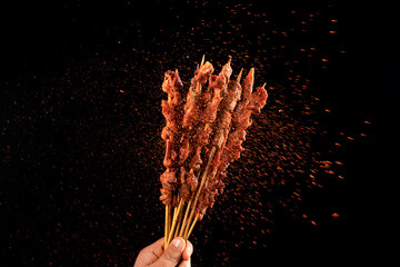 Shashlik. Kebab. Grilled barbecue meat with spices on black background - obrazy, fototapety, plakaty