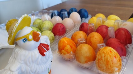 Easter chicken with colored eggs. Coloring Easter eggs. Sunday family gathering. Holiday and vacations. Blue, red, orange, green and yellow eggs. Easter decorations