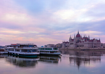 Fototapeta premium Morning in Budapest, parliament against the backdrop of a dramatic sky, ships on the river, reflected in the water