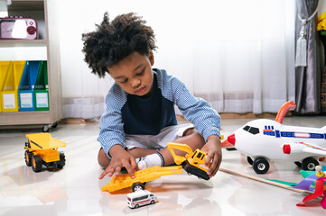 Happy black people African American child play truck and airplane toy at home 