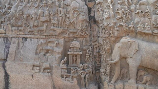 Bas relief rock cut sculptures of Elephant and human are carved in the monolithic granite rocks in Mahabalipuram, Tamil nadu. Ancient historical Indian rock art relief sculptures in large stone panel.