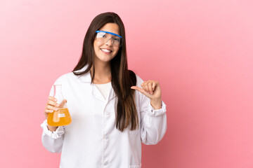 Young scientific girl over isolated pink background proud and self-satisfied