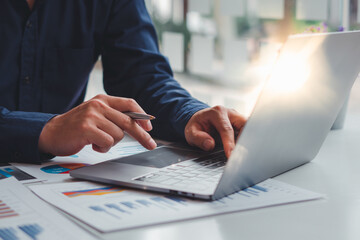 Financial market analyst,professional businessman working on new project with notebook computer while sitting at his office, flare light, blurred background