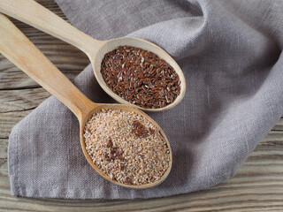 Linseed flour, flaxseed in wooden spoons, napkin on wooden background, top view, flat layout. A useful linum plant with omega and vitamins for use in cooking and vegetarian dietary nutrition