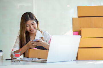 Fototapeta na wymiar Portrait of Starting small businesses SME owners female entrepreneurs working, box and check online orders to prepare to pack the boxes, sell to customers, sme business ideas online.