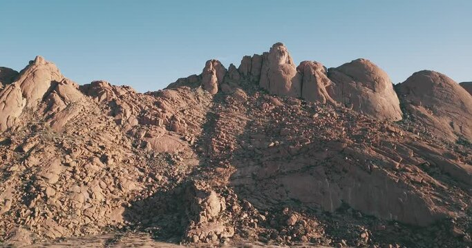 4K sunrise aerial footage of savanna, famous red granite Spitzkoppe Peak and Pontok Mountains in central Namibia between interior town Usakos and Atlantic west coast, southern Africa