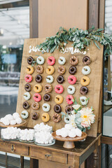 Candy bar with donuts of different colors on a wooden stand