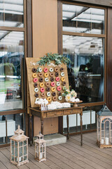 Candy bar with donuts of different colors on a wooden stand