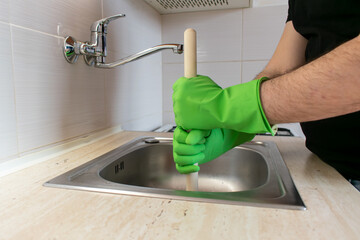 Drain Problems, blockage plumbing kitchen sink unclog plunger man hand hold