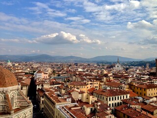 Fototapeta premium FIRENZE, ITALY. Panoramic view of Florence from the top of Duomo Santa Maria del Fiore. Tuscany hills on a horizon. Golden hour, cloudy sky. 