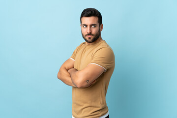 Fototapeta premium Young handsome man with beard over isolated background keeping the arms crossed