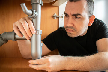 Drain Problems, blockage plumbing kitchen sink pipe unclog plunger man hand hold