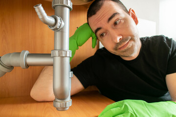 Drain Problems, blockage plumbing kitchen sink pipe unclog plunger man hand hold
