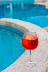 Aperol spritz at the pool. Cold summer drink by the pool. Alcohol drink with ice