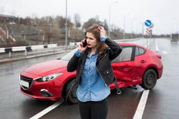 Woman calls to a service standing by a red car