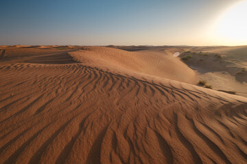Sunset over the sand dunes in the desert.
