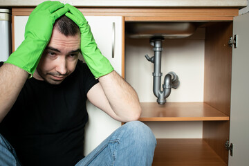 Drain Problems, blockage plumbing kitchen sink pipe unclog male man sit tired