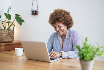 African senior woman working from home with computer laptop - Joyful elderly person and technology concept