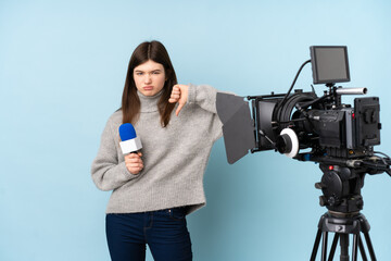 Young reporter woman holding a microphone and reporting news showing thumb down sign