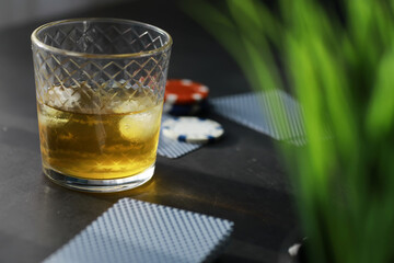 Gambling Card games for money. Texas Hold'em Poker. Cards in hand, playing chips, a deck of cards of alcohol in a glass.