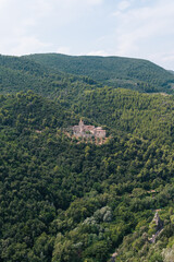 Fototapeta na wymiar abbey of San Cassiano near Narni, a Benedictine monastery in Italy. Distance view. Summer day. Vertical photo
