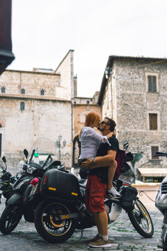 Two people and bike - woman and man. Couple in love. Adventure and vacations concept. Summer day. Vertical photo. Narni, Italy