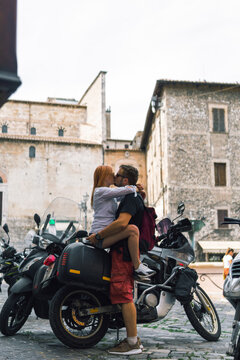Two people and bike - woman and man. Couple in love. Adventure and vacations concept. Summer day. Vertical photo. Narni, Italy