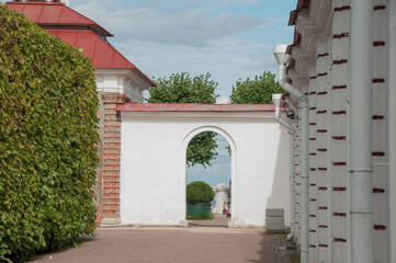 View of the topiary and the sea through the doorway in the white wall. Hidden park. Secret garden.