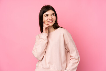 Young Ukrainian teenager girl over isolated pink background thinking an idea while looking up