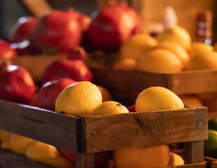Lemons, oranges, limes and pomegranates in wooden boxes. Fruit close up. selective focus