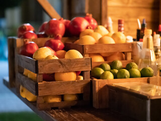 Lemons, oranges, limes and pomegranates in wooden boxes. Fruit close up. selective focus
