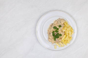 Chicken stew with muschrooms and french fries