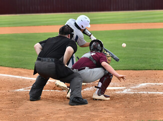 Action photo of athletic high school baseball player making an amazing play during a baseball game