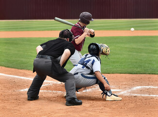 Action photo of athletic high school baseball player making an amazing play during a baseball game