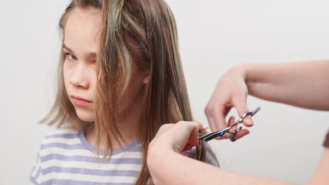 haircut. mom cuts off her daughter's hair with scissors. 