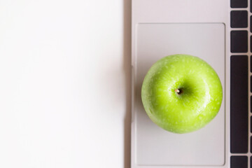 Healthy snack with working in office. Close up Green apple  for diet on white table working and white wooden background. Healthy and Lifestyle concept..