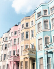 Fototapeta na wymiar Colourful houses of Notting Hill in London, bring and shiny in the daylight and blue sky above.