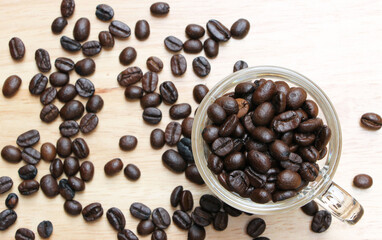 brown roasted organic coffee beans in a cup on a wooden table in a coffee shop