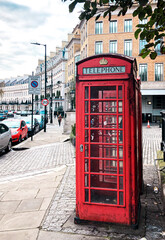 Fototapeta na wymiar A red telephone booth on the empty street in London.