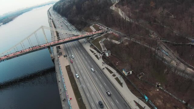 Copter view road with driving cars near river. Drone, cars trucks, forest, tourist, water, urban, infrastructure, city, architecture, aerial, travel. Slow motion
